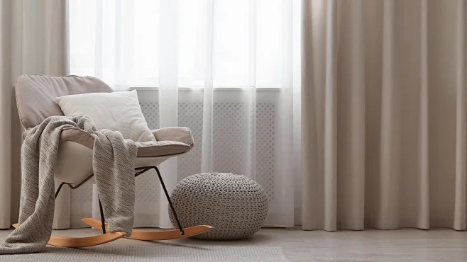 Cohesive home interior styling with neutral curtains, armchair cushion, and textured soft furnishings
